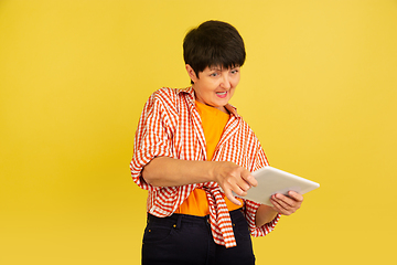 Image showing Senior woman isolated on yellow background. Tech and joyful elderly lifestyle concept