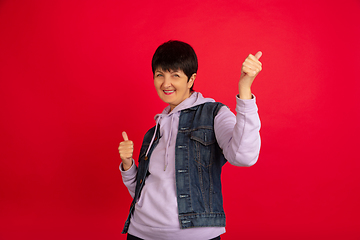 Image showing Senior woman isolated on red background. Tech and joyful elderly lifestyle concept