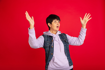 Image showing Senior woman isolated on red background. Tech and joyful elderly lifestyle concept