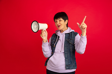 Image showing Senior woman isolated on red background. Tech and joyful elderly lifestyle concept