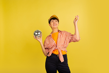 Image showing Senior woman isolated on yellow background. Tech and joyful elderly lifestyle concept