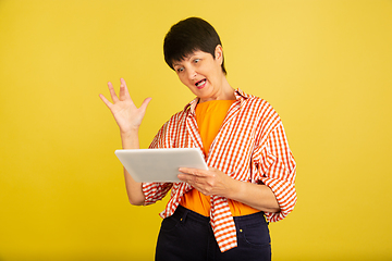 Image showing Senior woman isolated on yellow background. Tech and joyful elderly lifestyle concept