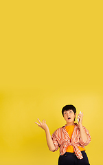 Image showing Senior woman isolated on yellow background. Tech and joyful elderly lifestyle concept