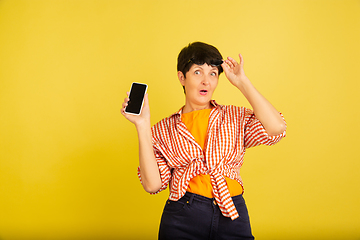 Image showing Senior woman isolated on yellow background. Tech and joyful elderly lifestyle concept