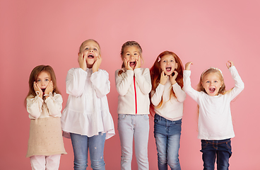 Image showing Portrait of little caucasian children with bright emotions isolated on pink studio background