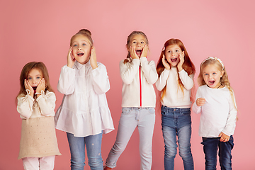 Image showing Portrait of little caucasian children with bright emotions isolated on pink studio background