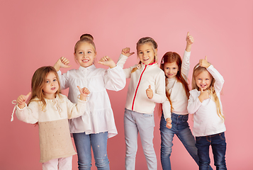 Image showing Portrait of little caucasian children with bright emotions isolated on pink studio background