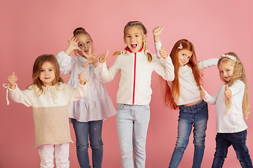 Image showing Portrait of little caucasian children with bright emotions isolated on pink studio background