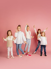 Image showing Portrait of little caucasian children with bright emotions isolated on pink studio background