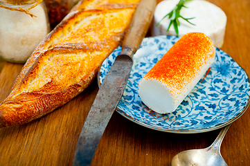 Image showing French cheese and fresh  baguette on a wood cutter