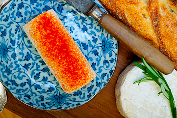 Image showing French cheese and fresh  baguette on a wood cutter