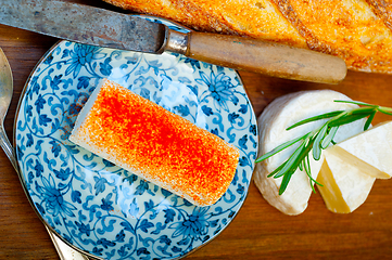 Image showing French cheese and fresh  baguette on a wood cutter