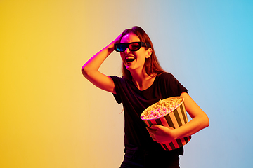 Image showing Young caucasian woman\'s portrait on gradient blue-yellow studio background in neon light