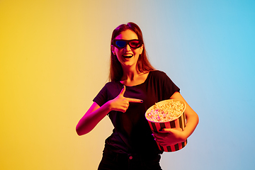 Image showing Young caucasian woman\'s portrait on gradient blue-yellow studio background in neon light