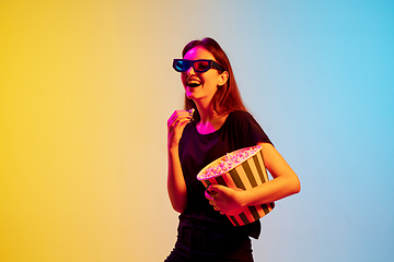 Image showing Young caucasian woman\'s portrait on gradient blue-yellow studio background in neon light