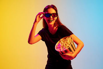 Image showing Young caucasian woman\'s portrait on gradient blue-yellow studio background in neon light