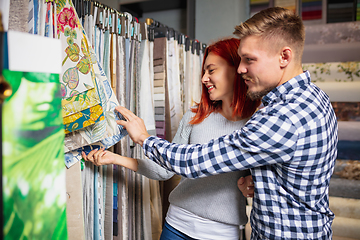 Image showing Couple choosing textile at home decoration store, shop. Making of home interior design during quarantine