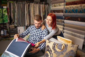 Image showing Couple choosing textile at home decoration store, shop. Making of home interior design during quarantine