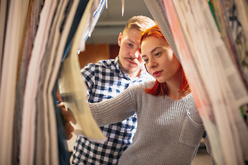 Image showing Couple choosing textile at home decoration store, shop. Making of home interior design during quarantine