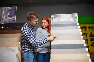 Image showing Couple choosing textile at home decoration store, shop. Making of home interior design during quarantine