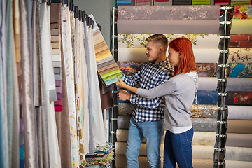 Image showing Couple choosing textile at home decoration store, shop. Making of home interior design during quarantine