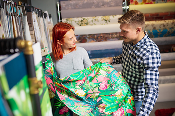 Image showing Couple choosing textile at home decoration store, shop. Making of home interior design during quarantine