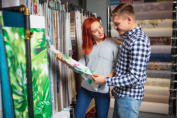 Image showing Couple choosing textile at home decoration store, shop. Making of home interior design during quarantine