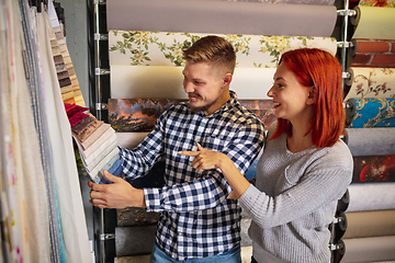 Image showing Couple choosing textile at home decoration store, shop. Making of home interior design during quarantine