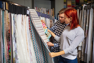 Image showing Couple choosing textile at home decoration store, shop. Making of home interior design during quarantine