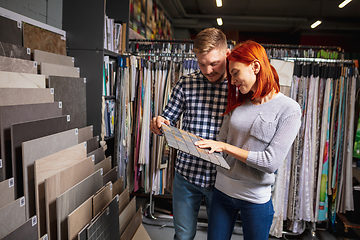 Image showing Couple choosing textile at home decoration store, shop. Making of home interior design during quarantine