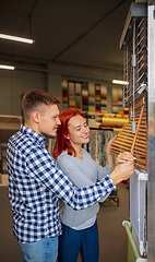 Image showing Couple choosing textile at home decoration store, shop. Making of home interior design during quarantine