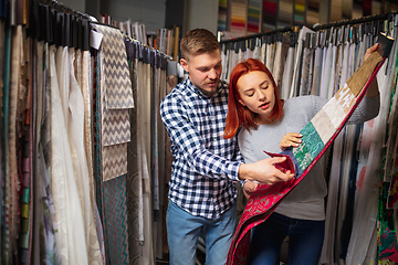 Image showing Couple choosing textile at home decoration store, shop. Making of home interior design during quarantine