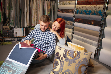 Image showing Couple choosing textile at home decoration store, shop. Making of home interior design during quarantine