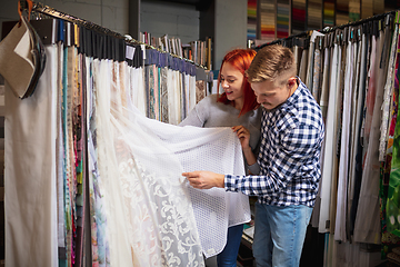 Image showing Couple choosing textile at home decoration store, shop. Making of home interior design during quarantine