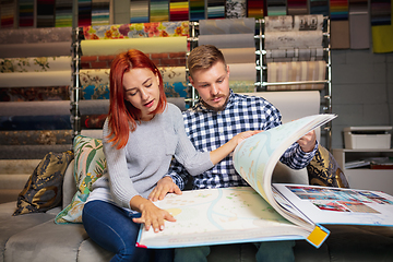 Image showing Couple choosing textile at home decoration store, shop. Making of home interior design during quarantine