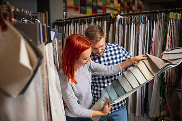 Image showing Couple choosing textile at home decoration store, shop. Making of home interior design during quarantine