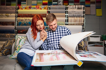 Image showing Couple choosing textile at home decoration store, shop. Making of home interior design during quarantine