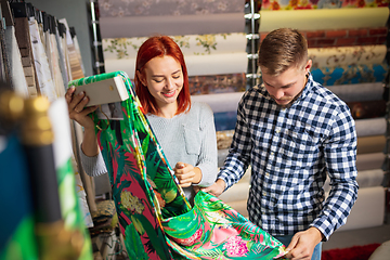 Image showing Couple choosing textile at home decoration store, shop. Making of home interior design during quarantine