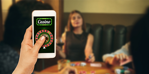 Image showing Online gambling, casino concept. Hand holding device with lottery, casino cover