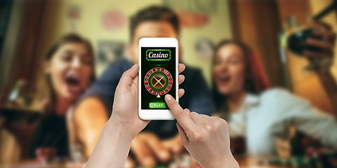 Image showing Online gambling, casino concept. Hand holding device with lottery, casino cover