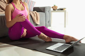 Image showing Beautiful young woman working out indoors, doing yoga exercise on gray mat at home