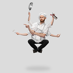 Image showing Cooker, chef, baker in uniform multitask like shiva isolated on gray studio background