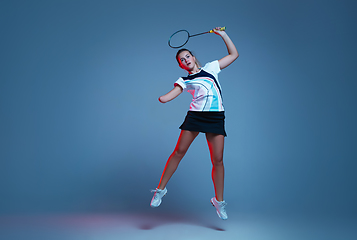 Image showing Beautiful handicap woman practicing in badminton isolated on blue background in neon light