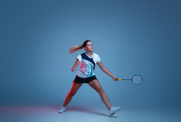 Image showing Beautiful handicap woman practicing in badminton isolated on blue background in neon light