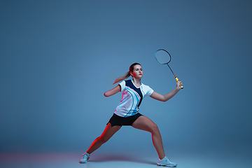 Image showing Beautiful handicap woman practicing in badminton isolated on blue background in neon light