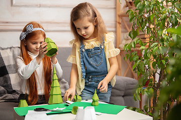 Image showing Two little children, girls together in creativity of the house. Happy kids make handmade toys for games or New Year celebration