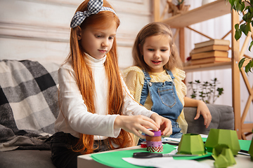 Image showing Two little children, girls together in creativity of the house. Happy kids make handmade toys for games or New Year celebration