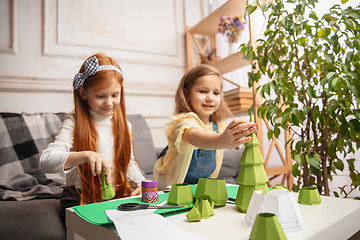 Image showing Two little children, girls together in creativity of the house. Happy kids make handmade toys for games or New Year celebration