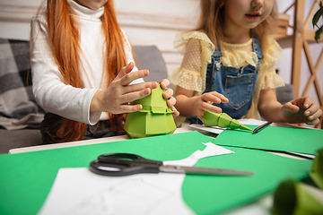 Image showing Two little children, girls together in creativity of the house. Happy kids make handmade toys for games or New Year celebration