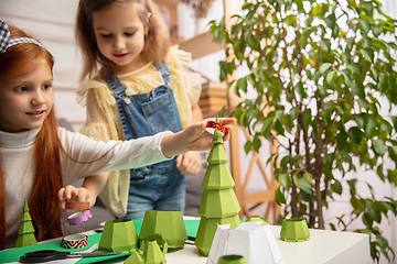 Image showing Two little children, girls together in creativity of the house. Happy kids make handmade toys for games or New Year celebration